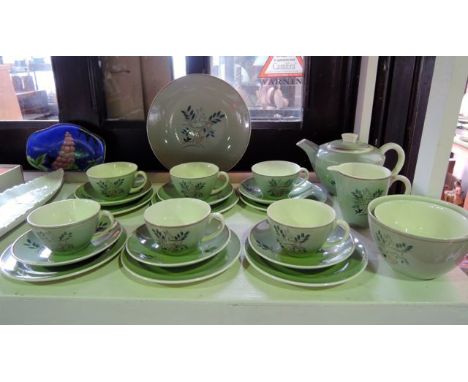 A Poole Pottery six place tea service with stylised painted leaping deer decoration on a green ground comprising teapot, milk