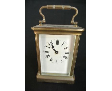 A brass carriage clock with enamel dial and 8 day timepiece