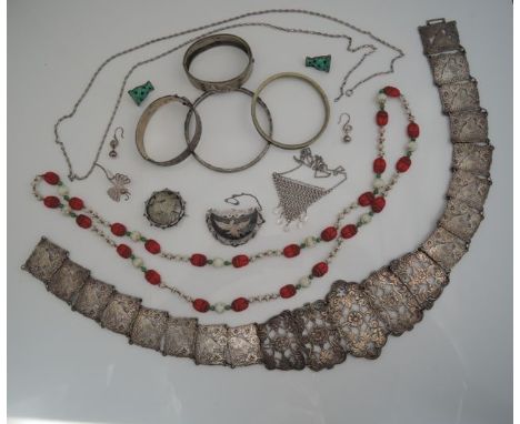 A Siam Sterling silver niello brooch, with winged figure, 9g; an Oriental bead necklace, highlighted with red beetles and gre