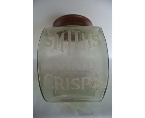 A vintage clear glass advertising jar of bulbous form with etched script Smith's Potato Crisps  with red Bakelite type circul