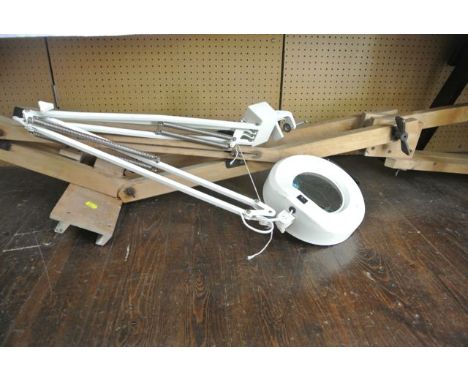 An artist's adjustable easel by Winsor & Newton Limited together with a magnifying light with adjustable stand
