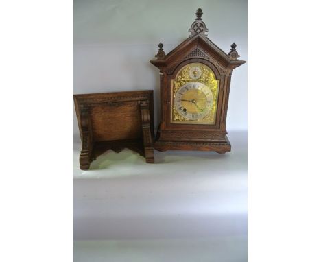 A small 19th century oak bracket clock and bracket, the architectural case with carved detail enclosing a broken arch, brass 
