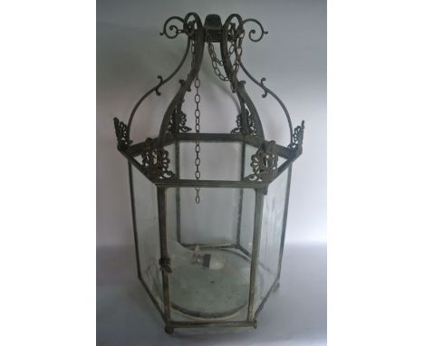 A vintage brass six sided hanging ceiling lantern set with clear glass panels to the sides, beneath a scrolling framework wit