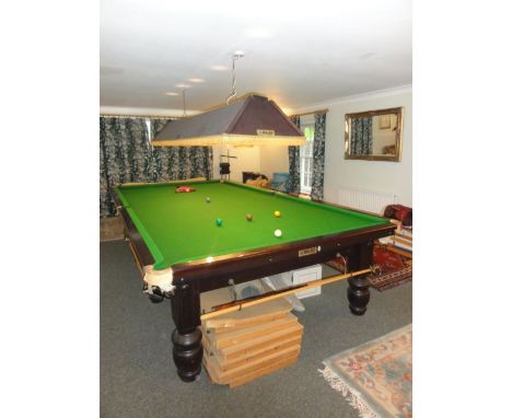 A full size Riley snooker table raised on turned supports, together with a set of balls, six rests, scoreboard, two long cues