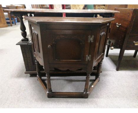 A reproduction oak floor standing low level corner cabinet, single door, linen fold panels to side, stretchers to base, 82cm 