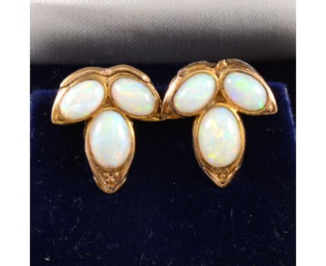 A pair of opal trefoil ear clips, the three oval cabochon cut opals set in 9 carat yellow gold closed back mounts, 15mm.