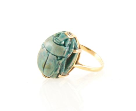 A green scarab dress ring, 16mm x 11mm, claw set in a yellow metal mount, ring size K.