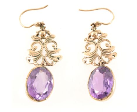 A pair of amethyst drop earrings, the oval mixed cut stones 15mm x 10mm, set in 9 carat yellow gold frames suspended from an 