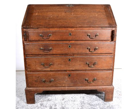 A George III oak bureau, fall front enclosing a part fitted interior, four graduating long drawers below, on bracket feet, wi
