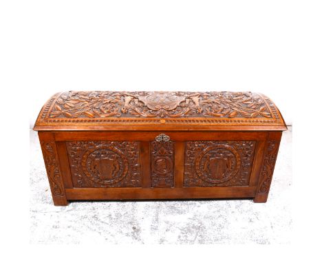 South American hardwood coffer, domed top, all over carved in higher relief, with cherub acanthus scrolls, front panel with p