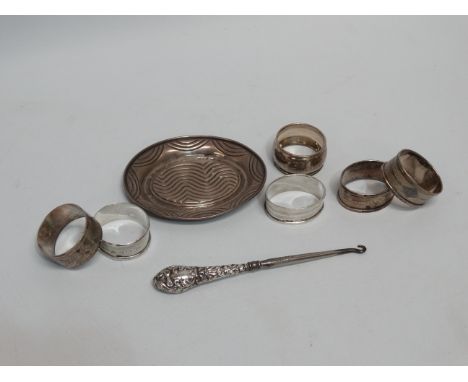 An pair of early 20th century silver napkin rings - oval with engine turning and a vacant cartouche, together with four furth