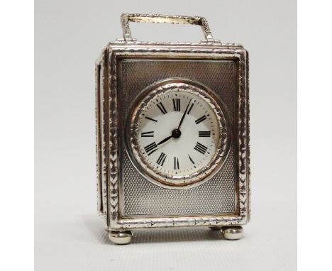 A silver cased carriage timepiece - London 1922, the engine turned case with harebell borders, raised on three ball feet, the