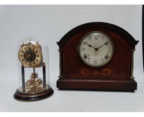 An Edwardian mahogany mantle clock - the case with foliate inlay and brass columns, the dial set out with Roman numerals with