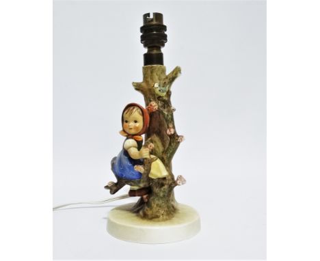 Hummel - a table lamp modelled with a young girl seated amongst branches, height 24cm. 