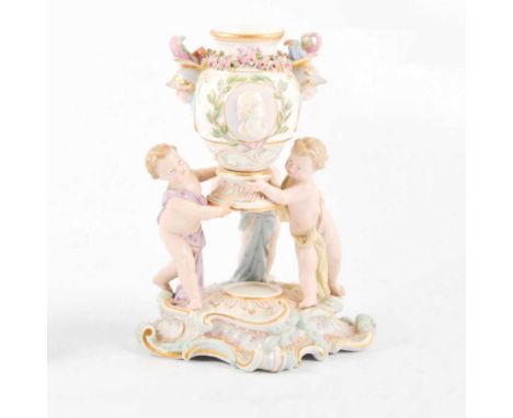 Dresden porcelain group, modelled with three cherubs supporting a classical urn, scrolled base, blue crossed swords mark, inc