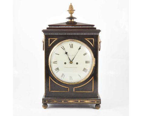 George IV ebonised bracket clock, pineapple finial, moulded top, the sides with lion mask handles and pierced grilles, circul