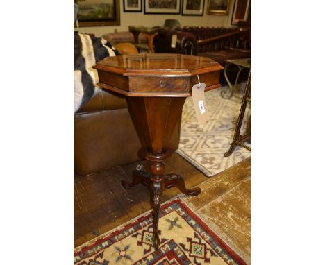 A mid Victorian figured burr walnut octagonal trumpet work table, the hinged top enclosing a compartmentalised interior, rais