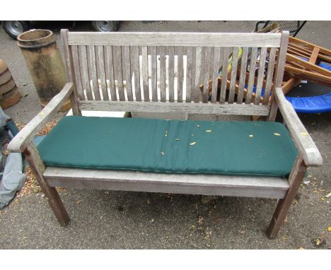 A teak garden bench, with slatted back and seat, 127cm wide.