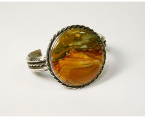 SILVER BANGLE. An American sterling silver bangle set with polished petrified wood. Max depth 4.5cm.