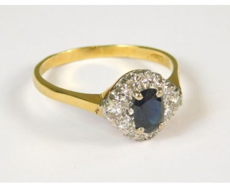 DIAMOND RING. An 18ct. gold oval sapphire &amp; diamond cluster ring. (S)