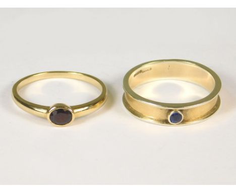 GOLD RINGS. A modern 9ct. gold ring, set an oval garnet &amp; a handmade 9ct. gold ring, set a blue stone.