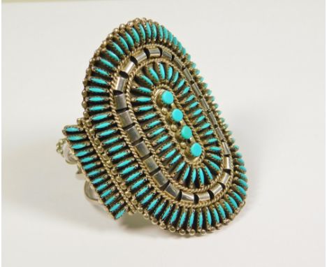 TURQUOISE BANGLE.A large North American Indian-style sterling silver bangle set with a 'needlepoint'arrangement of turquoise 