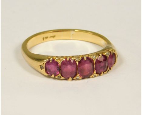 RUBY RING. An 18ct. gold, five stone ruby ring, further set with small native cut diamonds (one diamond missing). (O/P)