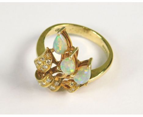 OPAL RING. A 14k opal ring set with three tear drop opals above a diamond set bow. (K/L)