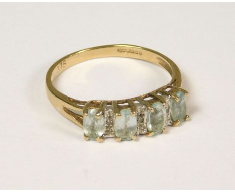 DRESS RING. A 9ct. gold dress ring set four pale blue stones &amp; diamonds. (N)