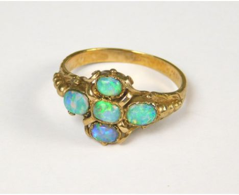 OPAL RING. A yellow metal ring set an arrangement of five opals. (N)