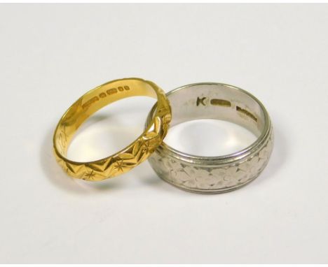 PLATINUM BAND ETC. A flower cast platinum band (K). Approx. 8.2g. Also an 18ct. gold engraved band (K) Approx. 2.4g.