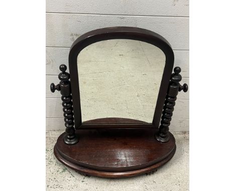 A free standing arched vanity mirror with bobbin sides 