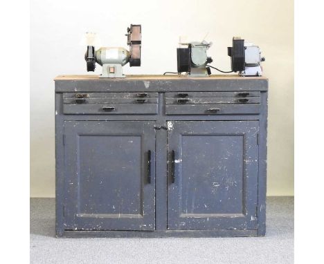 A wooden workshop bench, with three polishers