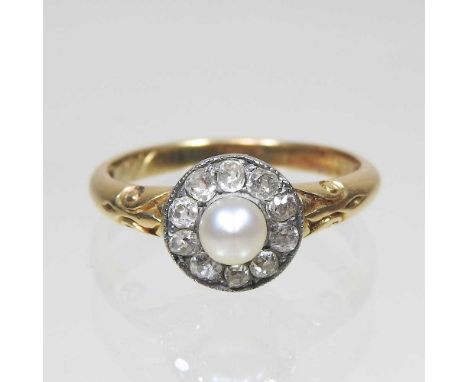 An early 20th century 18 carat gold pearl and diamond cluster memorial ring, with scrolled shoulders, inscribed 'In Memory of