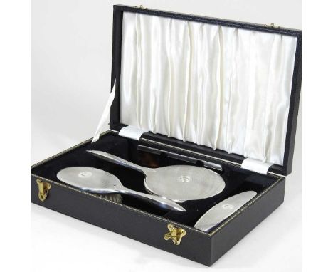 A mid 20th century silver mounted dressing table set, with hand mirror, brushes and comb, inscribed C, Birmingham 1947, in a 