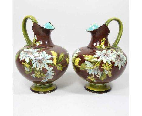 A pair of 19th century Doulton faience ewers, each painted with flowers on a brown ground, impressed and printed marks, 20cm 