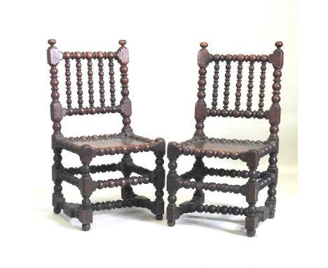 A pair of 17th century oak side chairs, each having a solid seat and bobbin turned supports48w x 43d x 95h cmOverall conditio