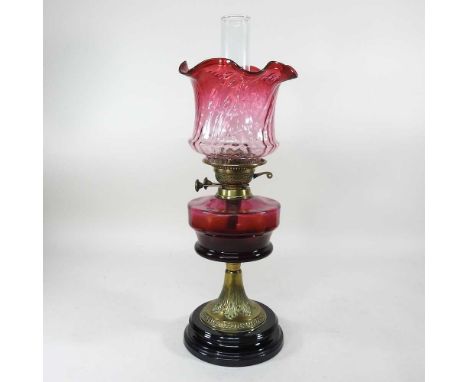 A Victorian brass oil lamp, with a coloured glass reservior and frilled shade, 50cm high