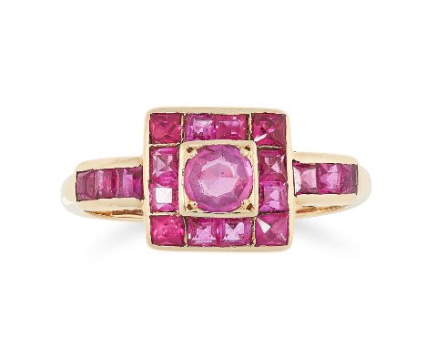 A RUBY CLUSTER DRESS RING, CIRCA 1950 in 18ct yellow gold, set with a central round cut ruby within a border of step cut and 