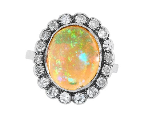 AN ANTIQUE ART DECO OPAL AND DIAMOND CLUSTER RING, EARLY 20TH CENTURY in platinum, set with an oval cabochon opal within a bo