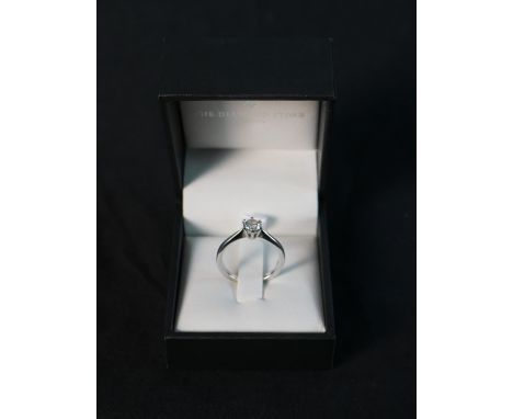 A boxed modern diamond and 18 carat white gold solitaire ring, set with a round brilliant cut diamond in an open back six cla