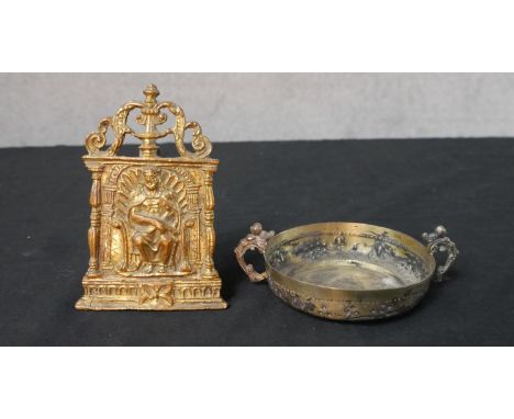 A 19th century gilt brass pocket easel shrine of a seated gentlemen together with a gilt brass twin handled porringer 
