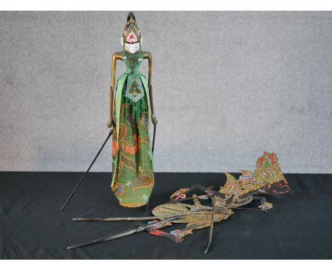 A carved and painted Javanese Wayang shadow puppet doll in silk clothing along with another Javanese shadow puppet. L.78 W.20