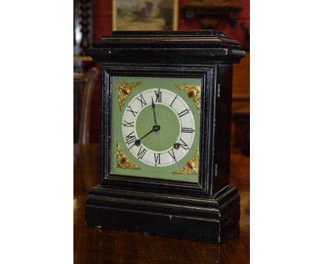 An Ansonia mantel clock, ebonised wooden case, painted square face, brass spandrels, Roman numerals, plinth base.