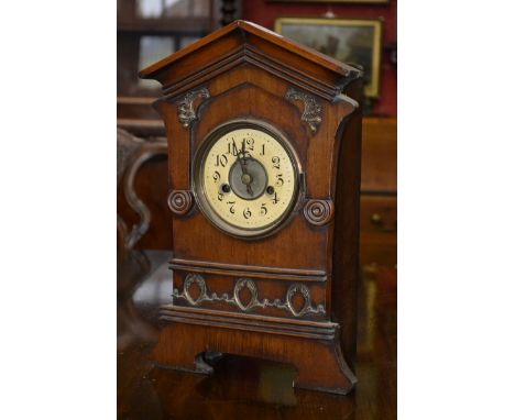 A mahogany cased mantel clock, architectural pediment, Arabic numerals.