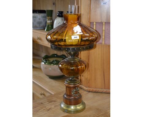 An electric table  lamp with amber glass shade and faux reservoir