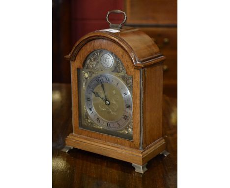 A George II design mahogany mantel clock, by Elliott, brass carrying handle and bracket feet