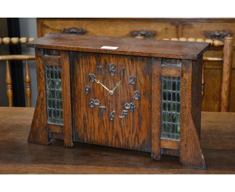 An Arts and Crafts oak mantel clock.