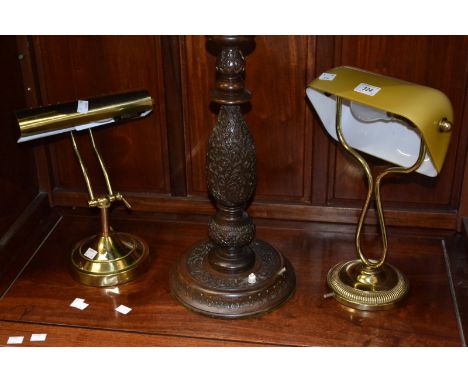 Two brass effect desk lamps; another carved wooden table lamp.