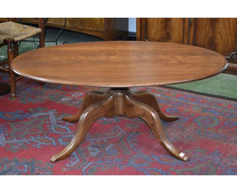 An Ercol coffee table, oval top, turned column, four cabriole supports.